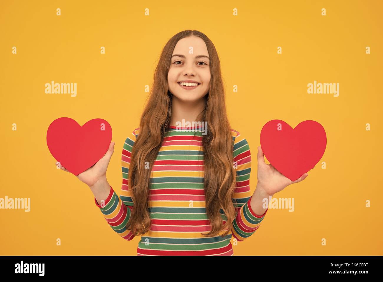 Teenage girl hold shape heart, heart-shape sign. Child holding a red heart love holiday valentine symbol. Stock Photo