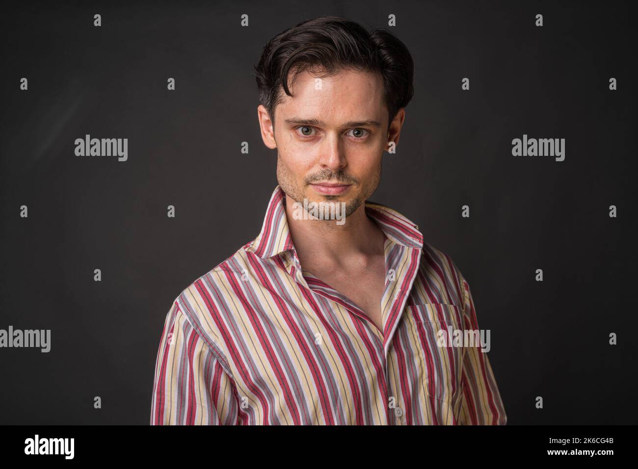 Studio portrait of handsome Caucasian man against gray background Stock Photo