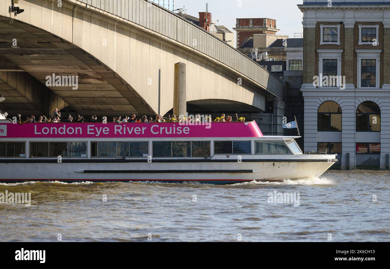 The London Eye river cruise boat travels down the Thames under London