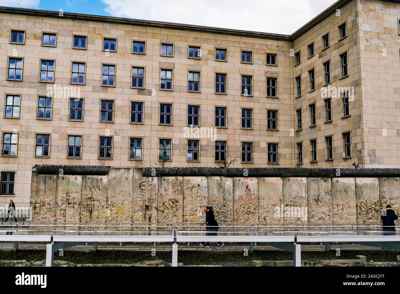 Third Reich (Ministry of Aviation) with rows of windows. the Berlin Wall and people walking along. Stock Photo