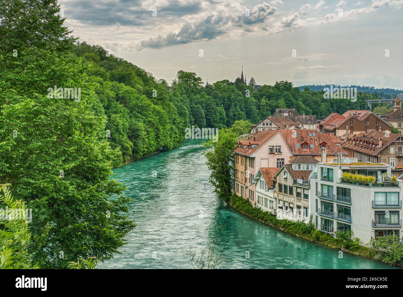 Aerial view of the clear River Aare in Bern, Switzerland with lush forest on one bank, typical Swiss houses on the other side shows a relaxed lifestyl Stock Photo