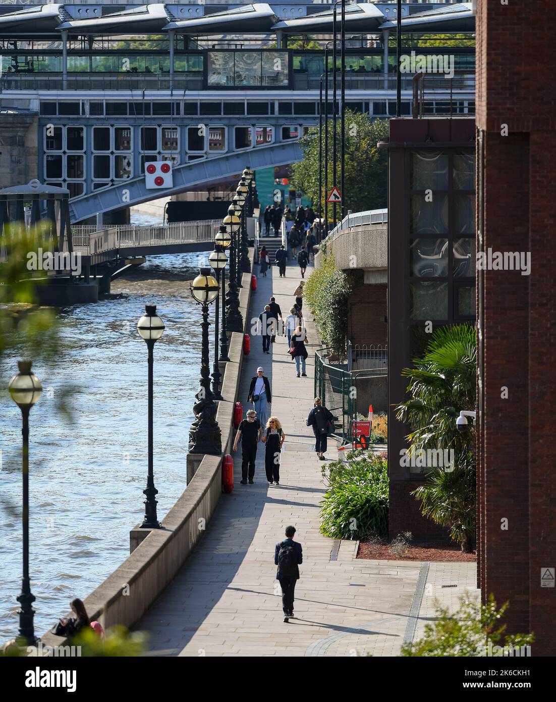 A view looking from Millennium Bridge towards Blackfriars Railway bridge along St Pauls Walk with people walking in the afternoon sun. Stock Photo