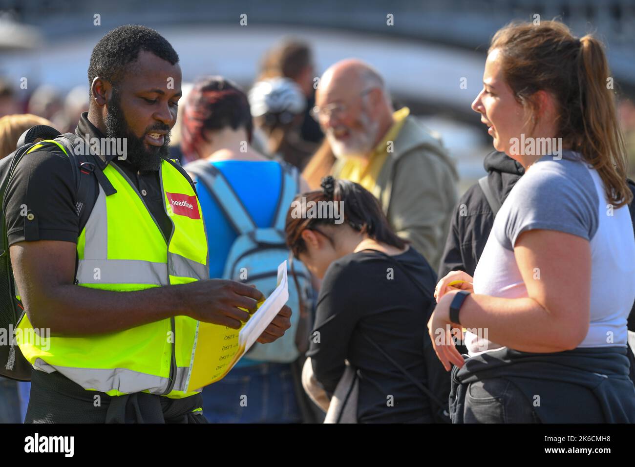 Members of the public receiving wrist bands as they join the queue on day one to visit the Queen lying in State at Westminster Hall London UK. Stock Photo