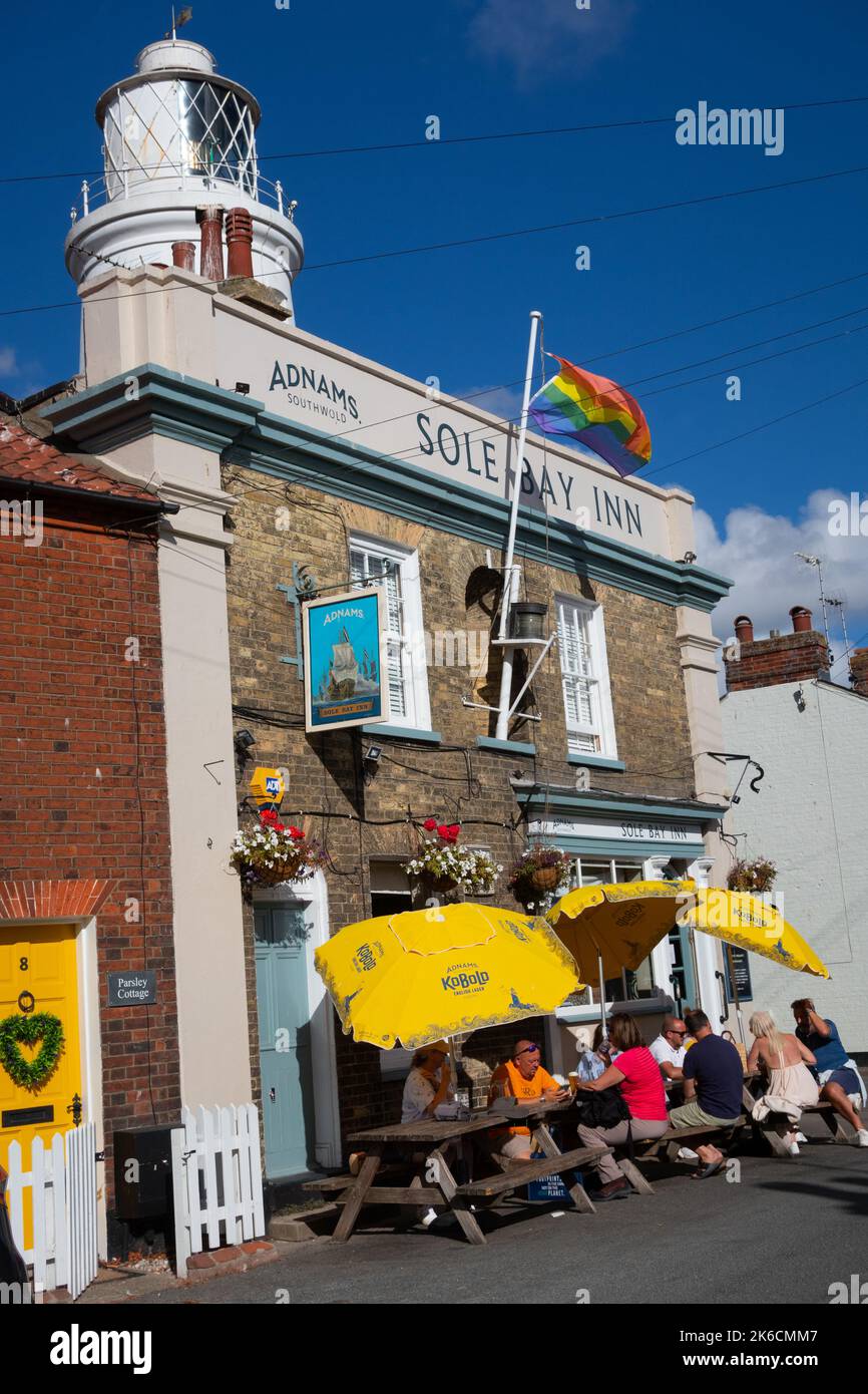 Customers sitting outside the Sole Bay Inn at Southwold with lighthouse