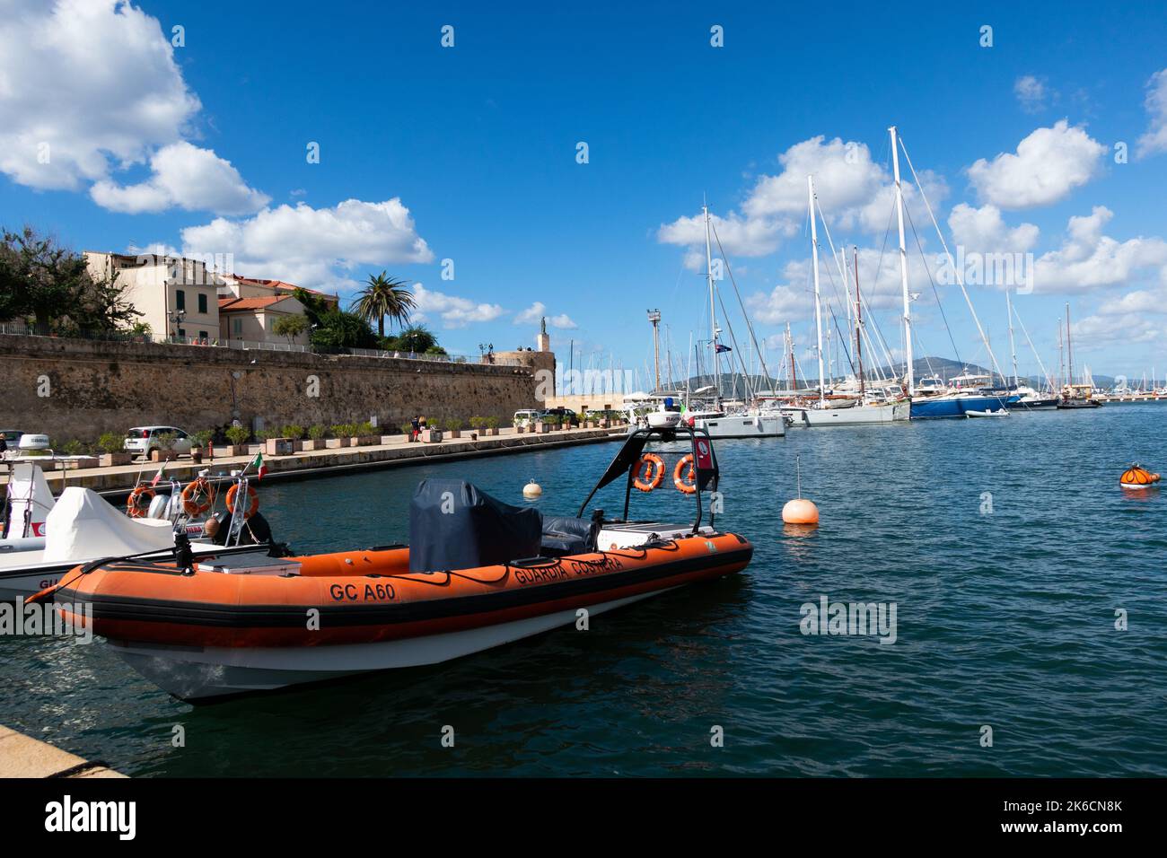 Alghero marina in the harbour with the 14th century defensive seawalls behind Stock Photo