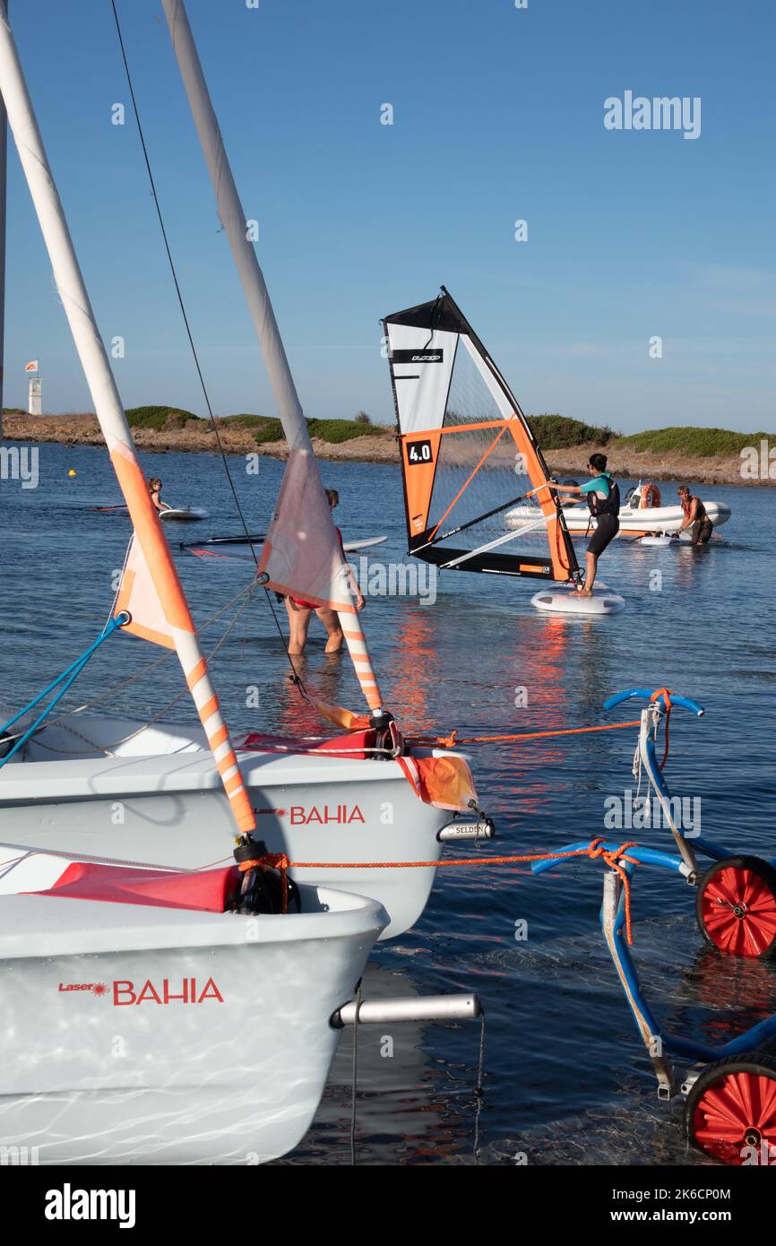 Laser Bahia sailing boats and windsurfer at Neilson Baia dei Mori Beach Club Sardinia Stock Photo