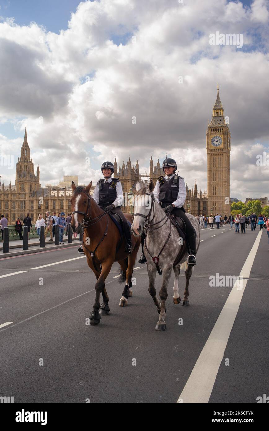 2 metropolitan mounted police officers ride over Westminster Bridge London with the Palace of Westminster in the background.Day 1Queen lying in state. Stock Photo