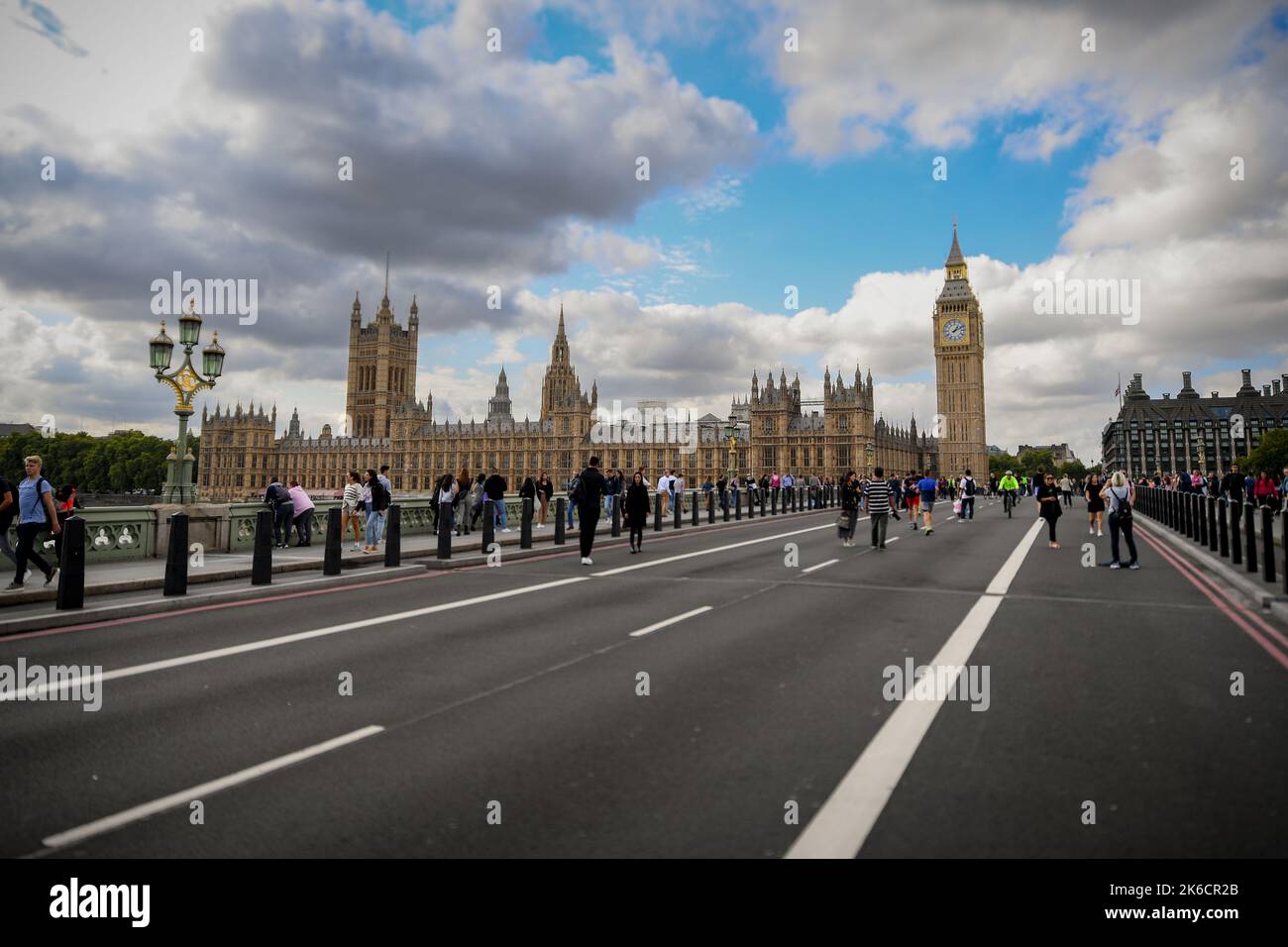 Houses of Parliament seen from Westminster bridge which is shut to traffic so people can walk on the road giving an unusual view. Stock Photo