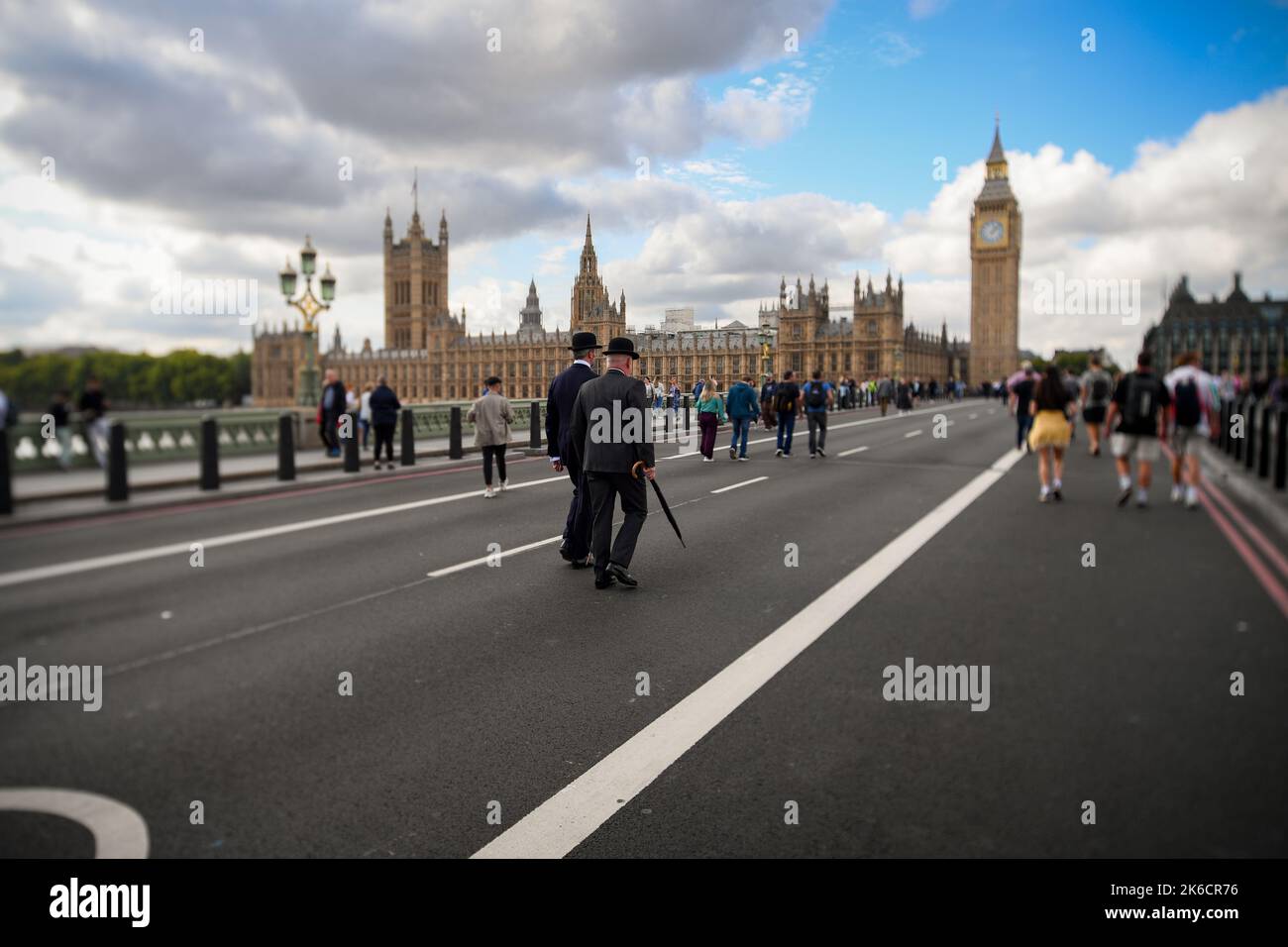 2 Grenadier Guards walk over Westminster Bridge in traditional bowler hats, suit & Umbrella on the day the Queens coffin is moved to Westminster Hall. Stock Photo