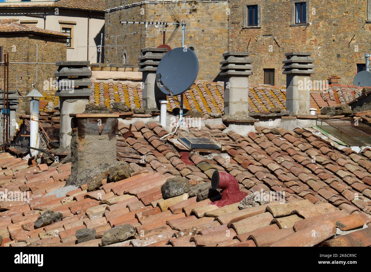 Chaotic situation on roofs: view on roof tiles, chimneys and antennas on the roofs of an old village in Tuscany, Italy Stock Photo