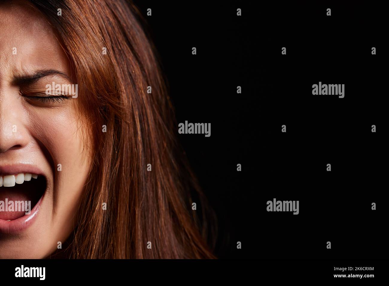 Louder than the voices in my head. a young woman experiencing mental illness against a black