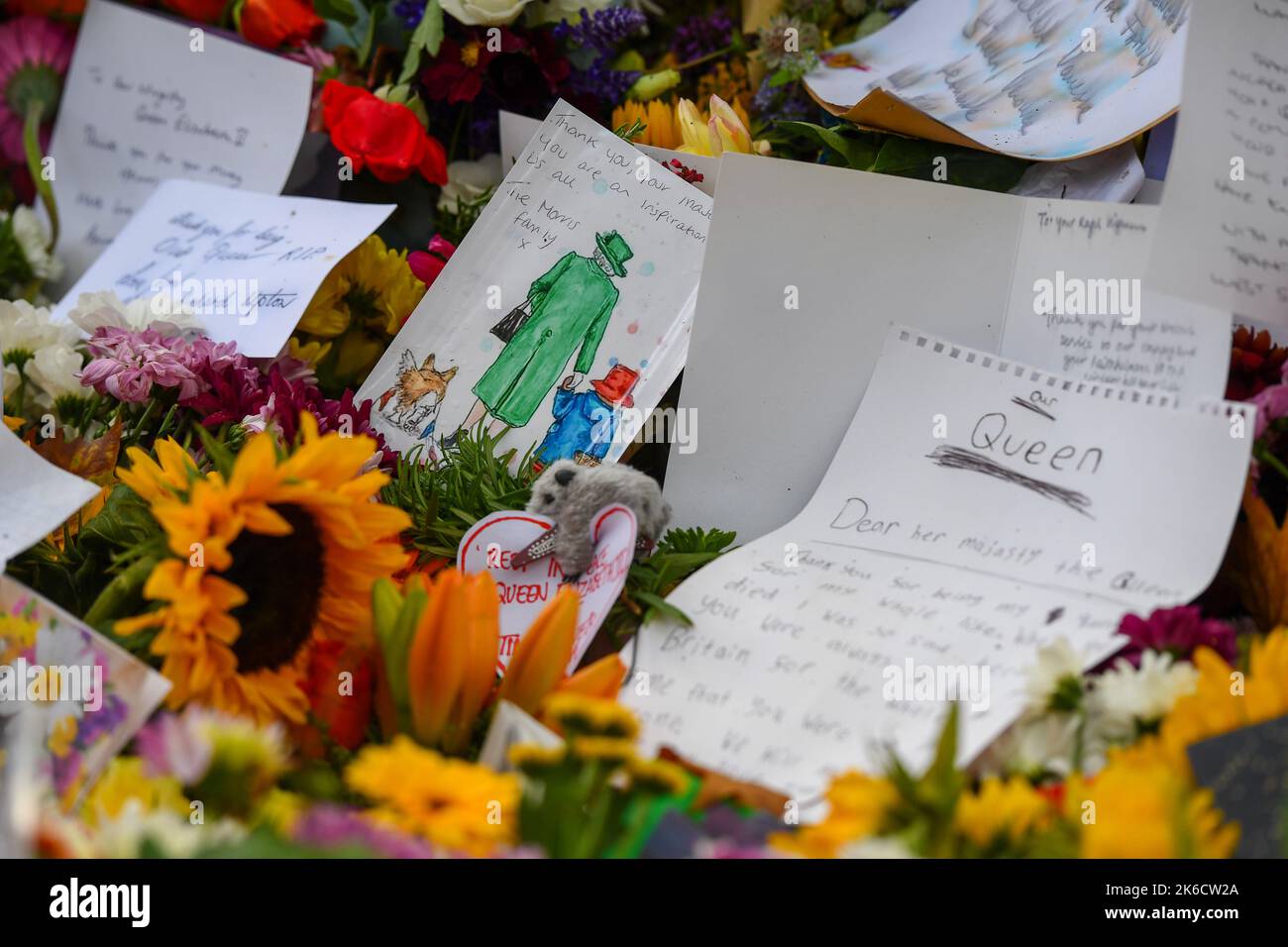 A drawing of the Queen and Paddington bear with corgis sits amongst the tributes and flowers laid for the Late Queen in Green Park London UK. Stock Photo