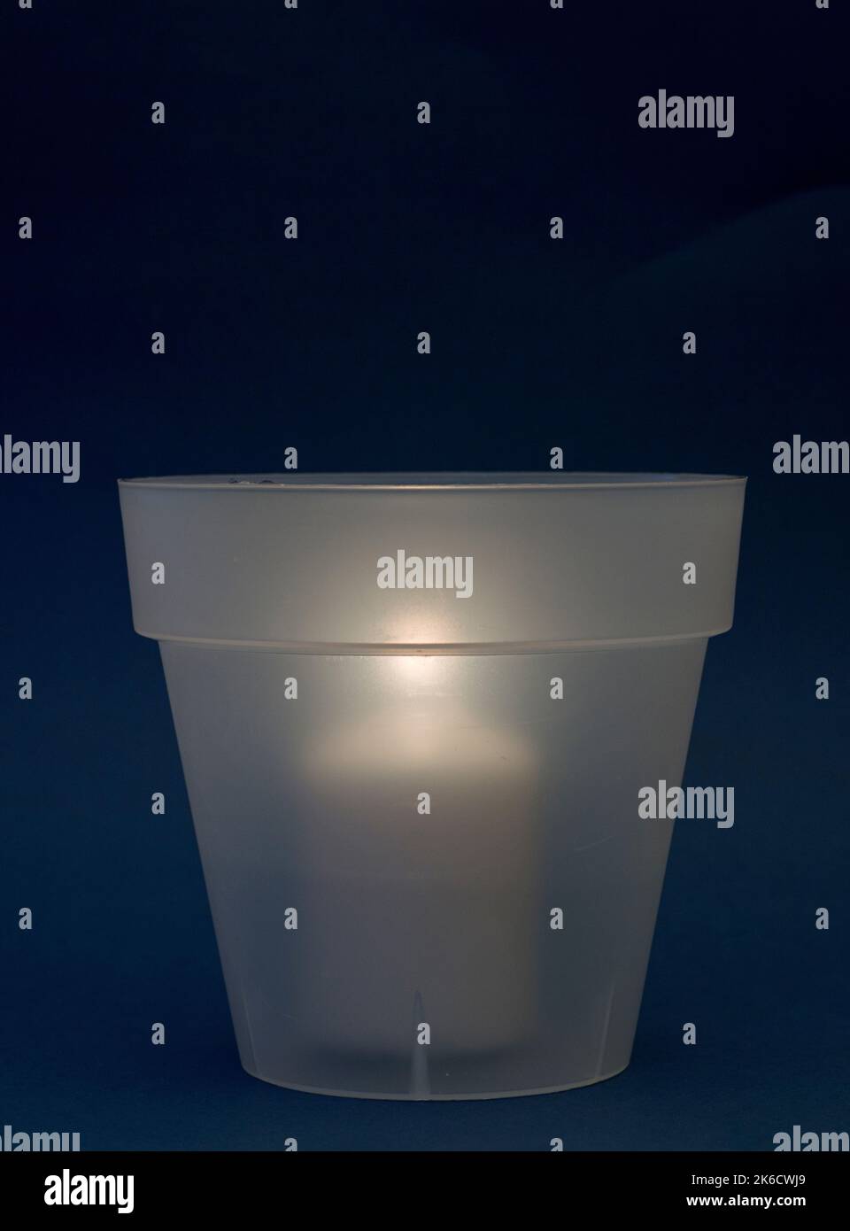 concept energy cuts, DIY lamp, pot and candle indoors, on the desk, dark blue background Stock Photo