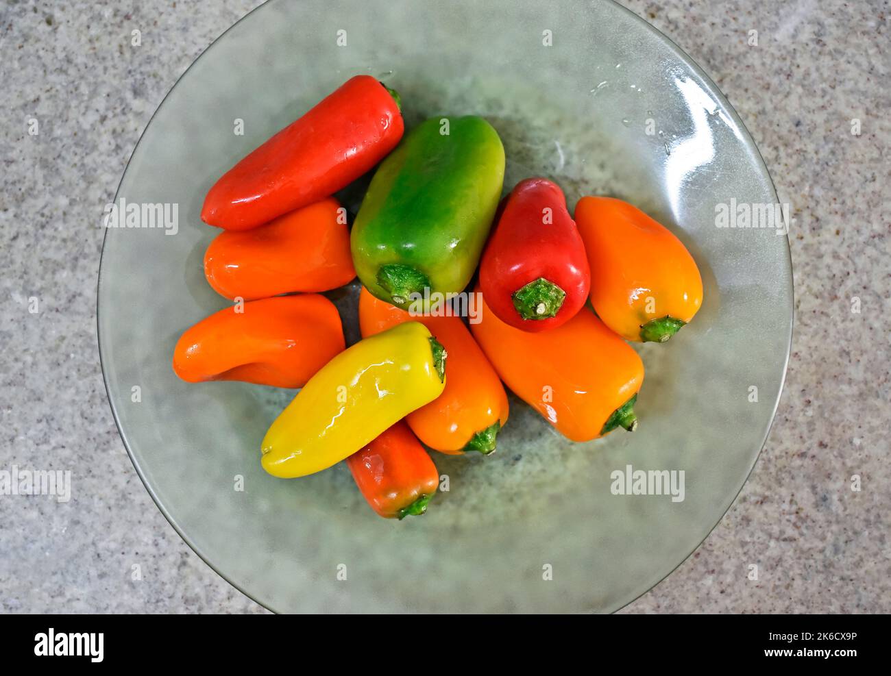 Mini bell peppers on glass plate in a granite background Stock Photo Alamy