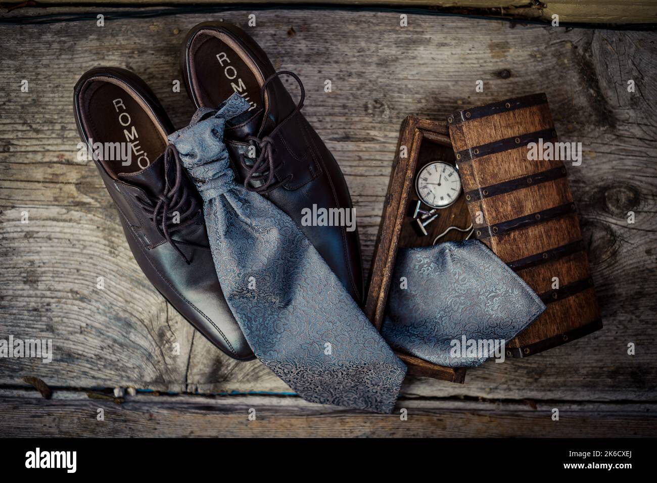 Groom's accessories at an elegant wedding: Shoes, cravat, watch and breast pocket handkerchief in a vintage jewel case Stock Photo