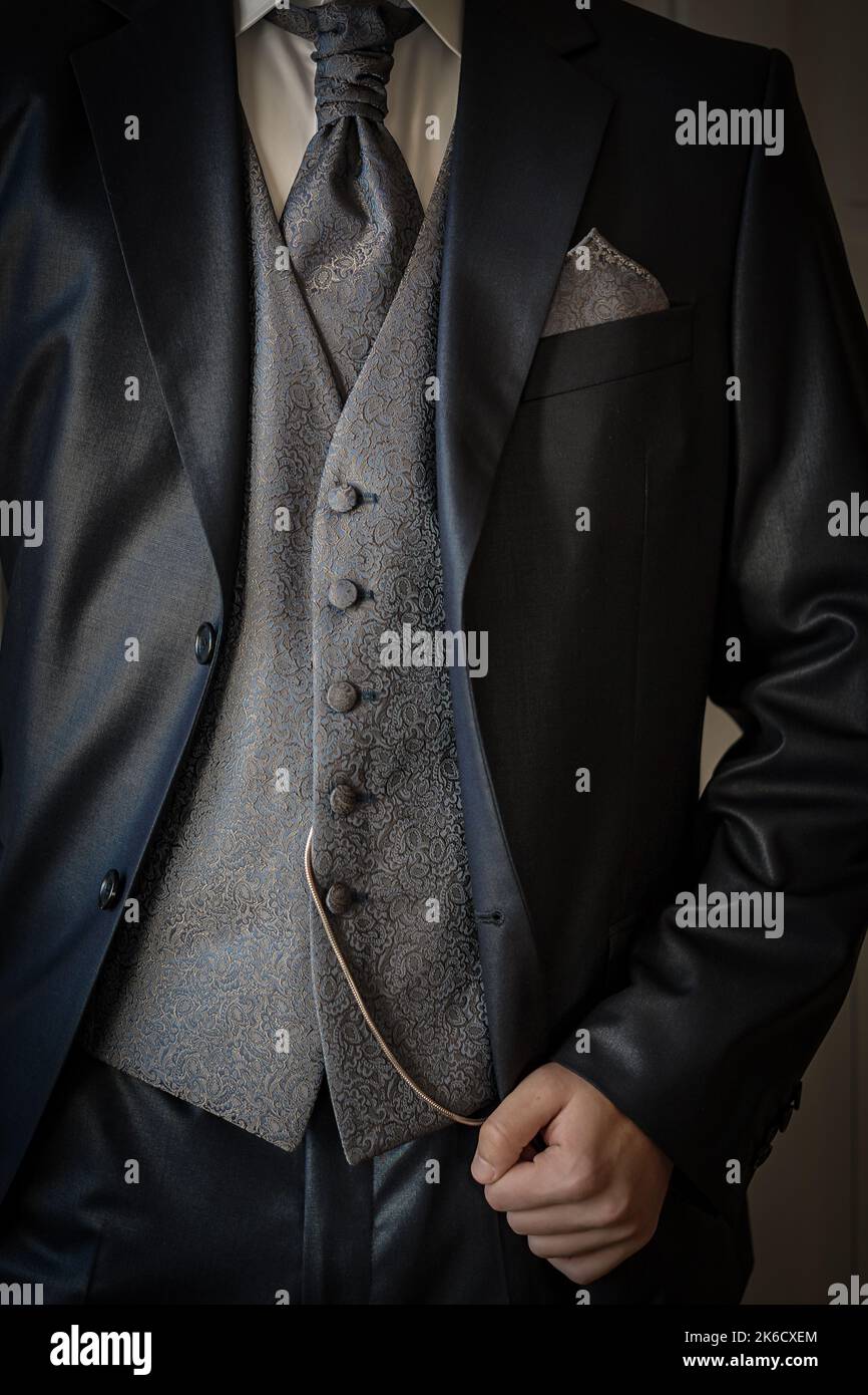 Detail of a groom at the wedding morning dressed in an elegant three-piece vintage suit with waistcoat, plastron and fob watch Stock Photo