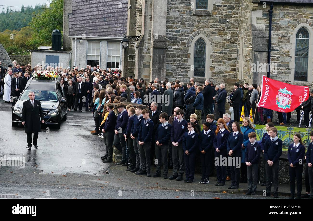 Family and mourners follow the hearse carrying Leona Harper's coffin as