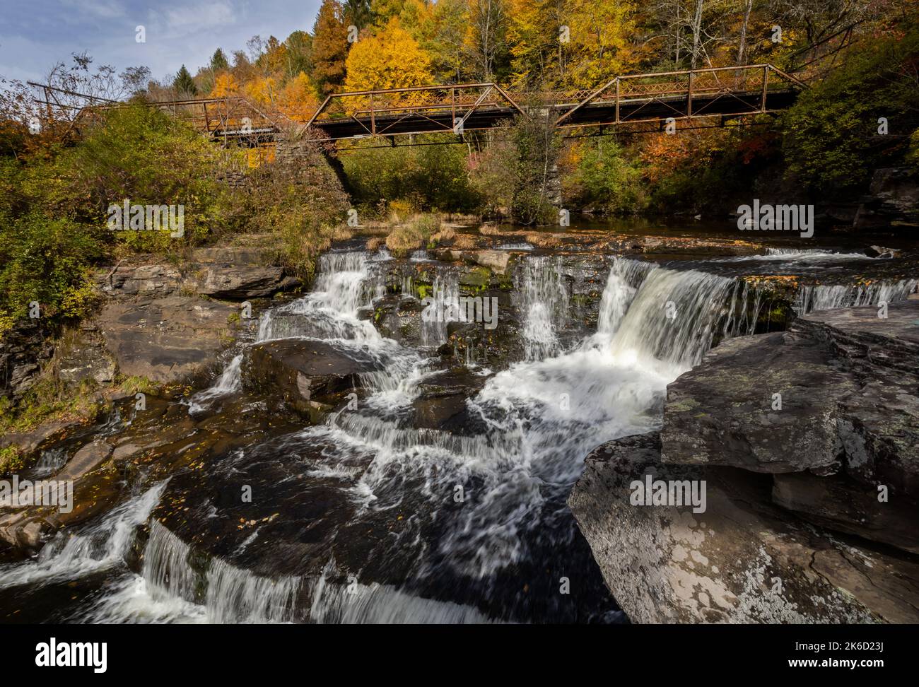 Tanners Falls in the Poconos near Honesdale, PA, on a brilliant fall day, which features multiple cascades and a historic bridge Stock Photo