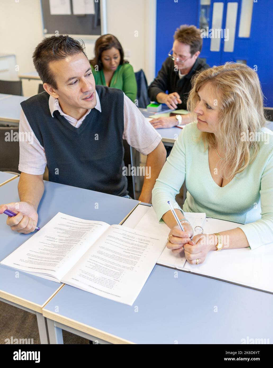 Adult Education: Teaching Advice. A teacher providing some individual tuition to a mature student. From a series of related images on the subject. Stock Photo