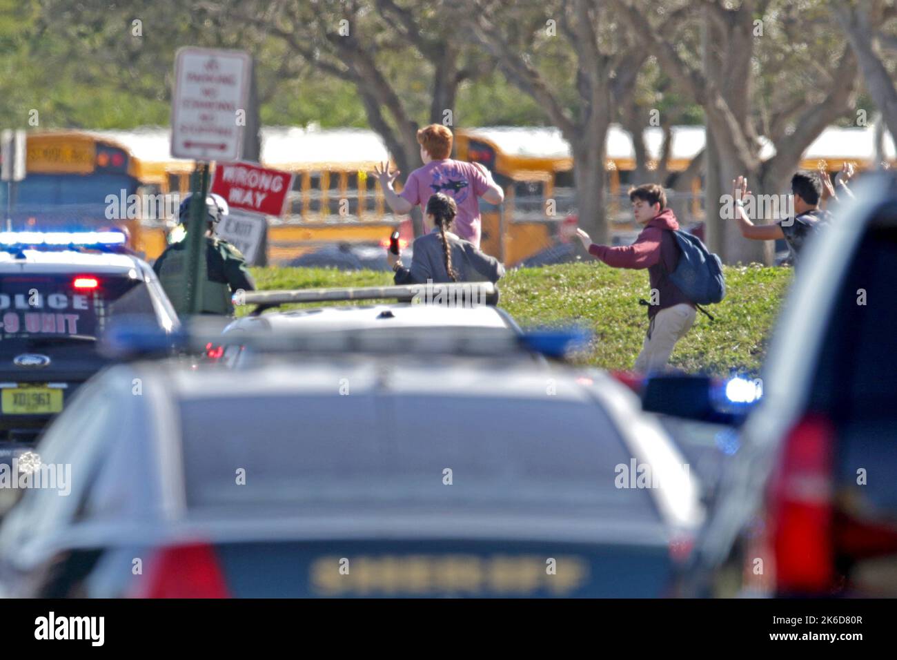 Parkland, USA. 14th Feb, 2018. Students run wth their hands in the air outside of Stoneman Douglas High School in Parkland, Fla., after a shooting on Wednesday, Feb. 14, 2018. (Photo by John McCall/Sun Sentinel/TNS/Sipa USA) Credit: Sipa USA/Alamy Live News Stock Photo