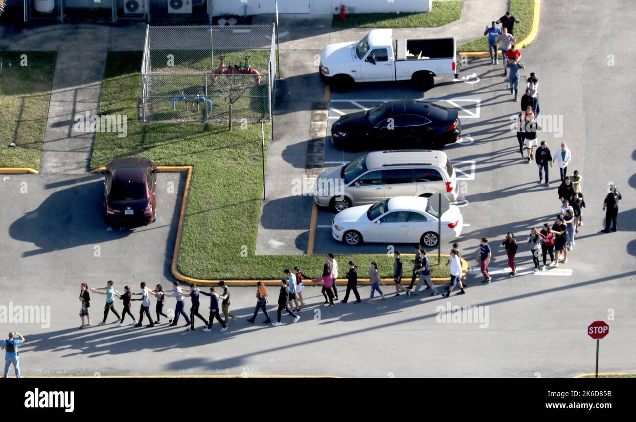 Parkland, USA. 14th Feb, 2018. Students are evacuated by police out of Stoneman Douglas High School in Parkland, Fla., after a shooting on Wednesday, Feb. 14, 2018. (Photo by Mike Stocker/Sun Sentinel/TNS/Sipa USA) Credit: Sipa USA/Alamy Live News Stock Photo