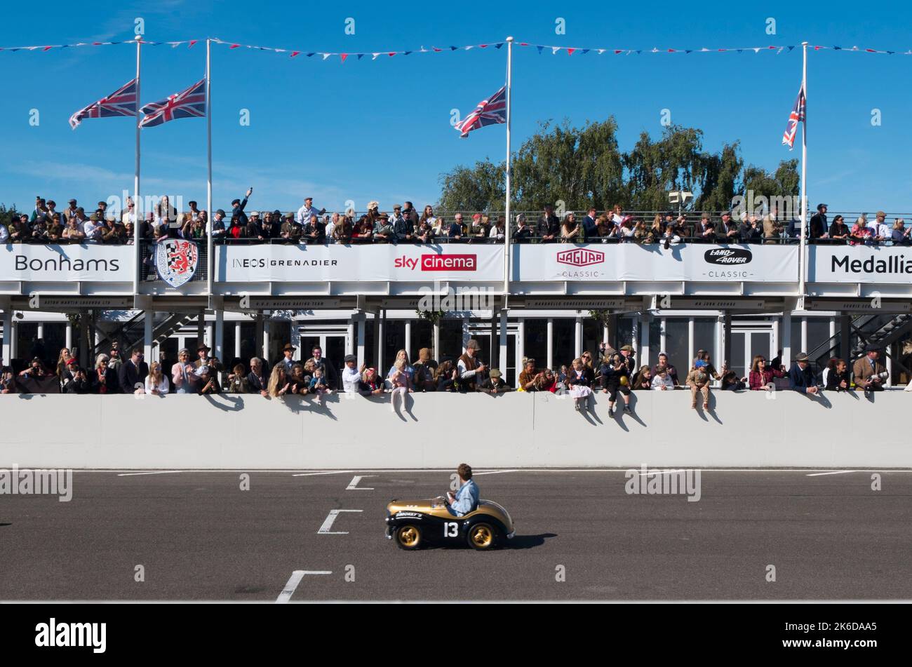 Kids racing in their Austin J40 pedal cars on the straight in the Settrington Cup race, Revival Meeting, Goodwood motor racing circuit, Goodwood, UK Stock Photo