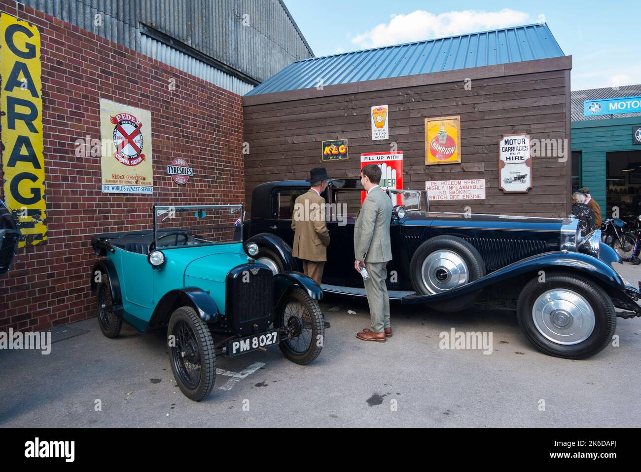 A small 1930s Austin 7 parked next to a large 1930s Rolls Royce at the BARC Revival Meeting, Goodwood motor racing circuit, Chichester, West Sussex,UK Stock Photo