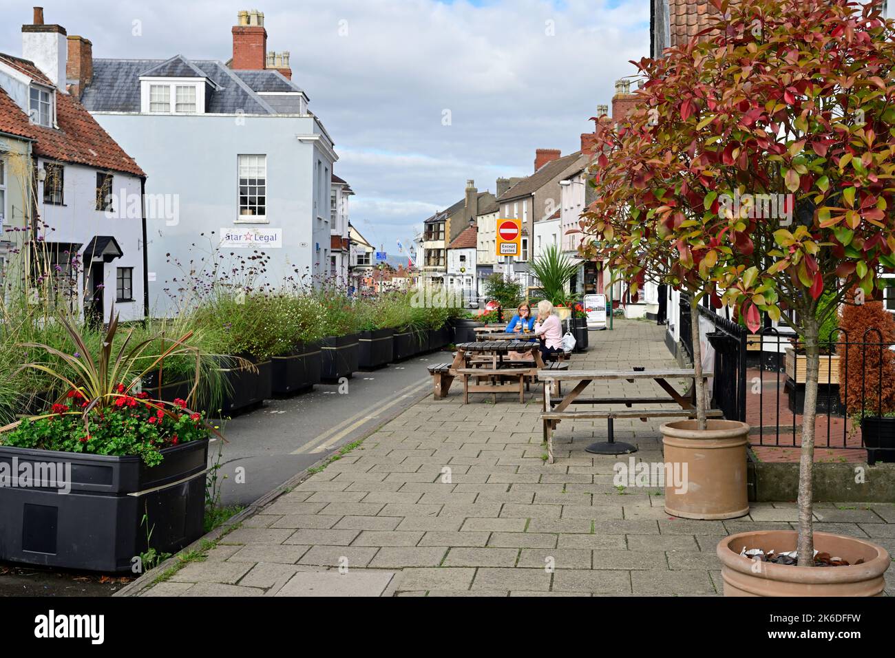 Pedestrianized area of Thornbury town centre with controversial closing of road to cars with planters and tables on pavement Stock Photo