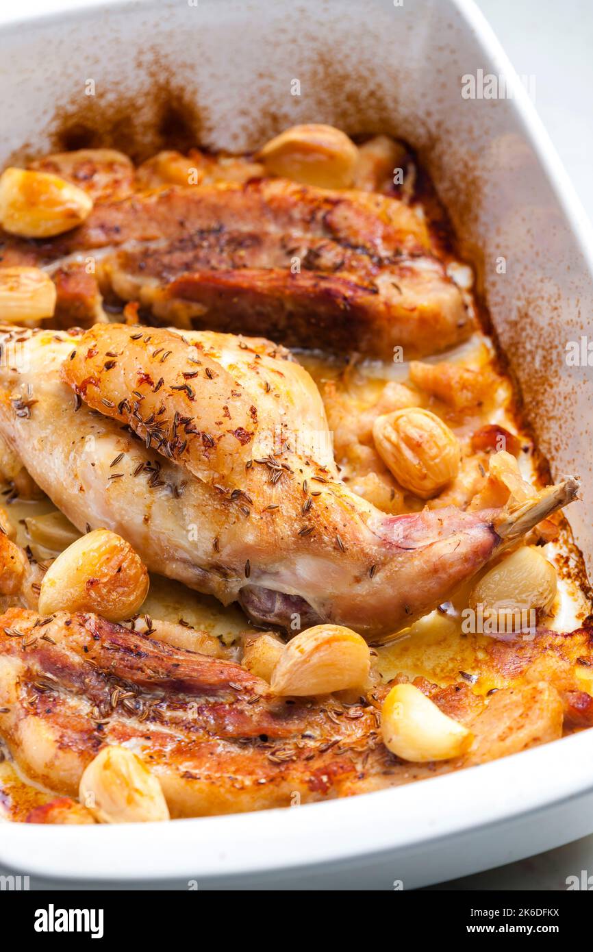 baked rabbit leg with garlic and bacon Stock Photo Alamy