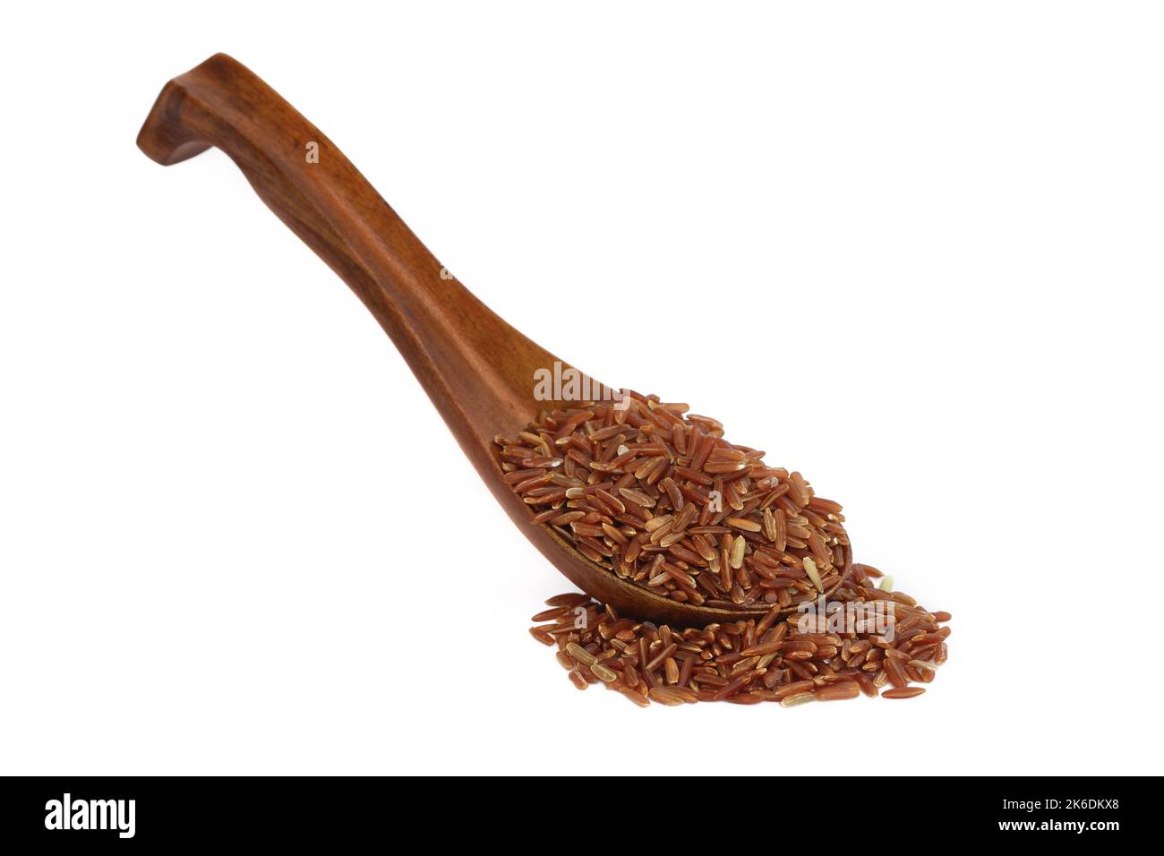 red rice in wooden spoon over white background Stock Photo - Alamy