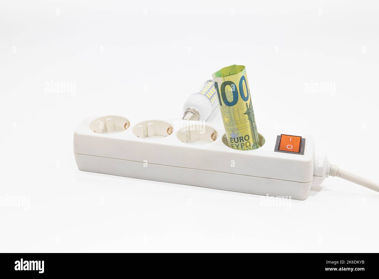 Euro banknotes are stuck in an electric power strip. Concept of the increasing electricity prices Stock Photo