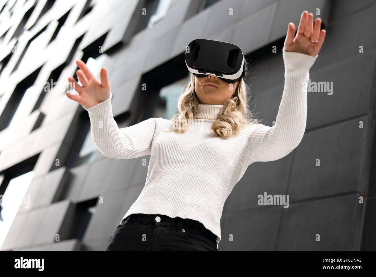 Woman Gesturing Using Virtual Reality Glasses In Metaverse Business Stock Photo