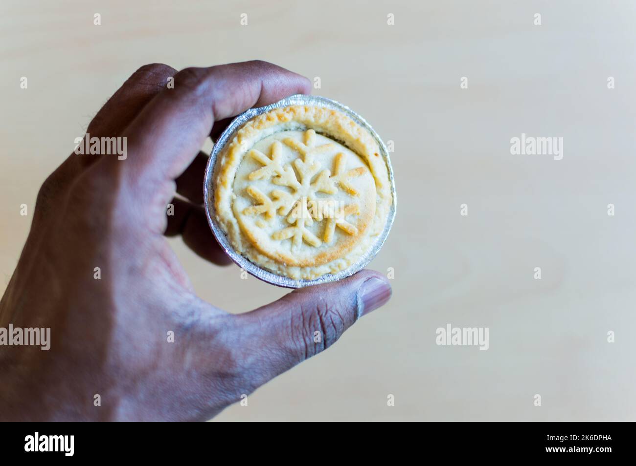 Adult male holding a minced fruit pie with festival decoration on top Stock Photo