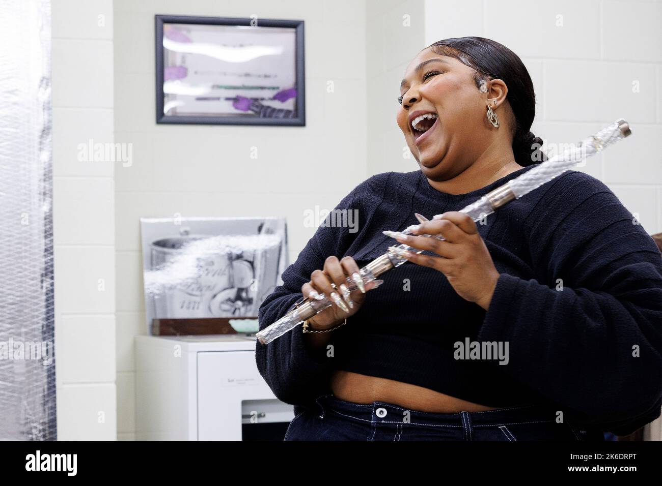 Washington, United States of America. 26 September, 2022. Pop singer and songwriter Lizzo laughs as she tries out a 200-years-old crystal flute during a tour of the Music Division at the Library of Congress, September 26, 2022 in Washington, D.C. The flute once belonged to the fourth President of the United States, James Madison.  Credit: Shawn Miller/Library of Congress/Alamy Live News Stock Photo