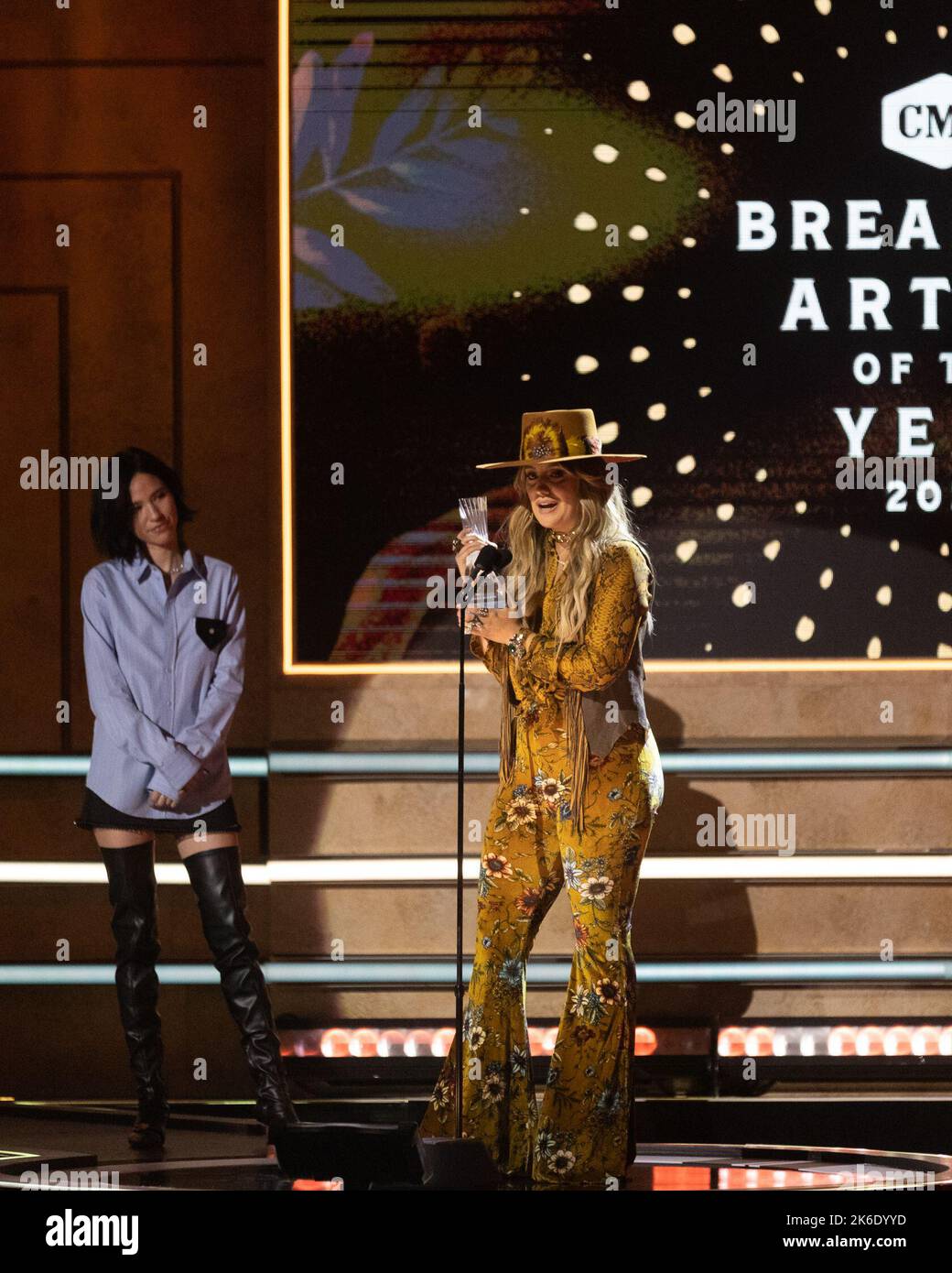 Lainey Wilson (R) accepts award on stage at the CMT Artists of the Year
