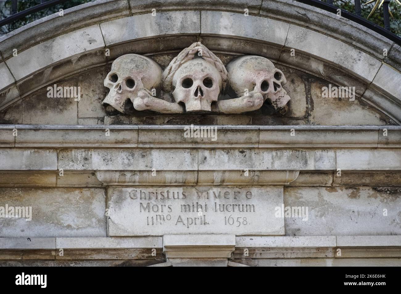 Skulls over the entrance to the churchyard at Saint Olave's Church of England, London England United Kingdom UK Stock Photo