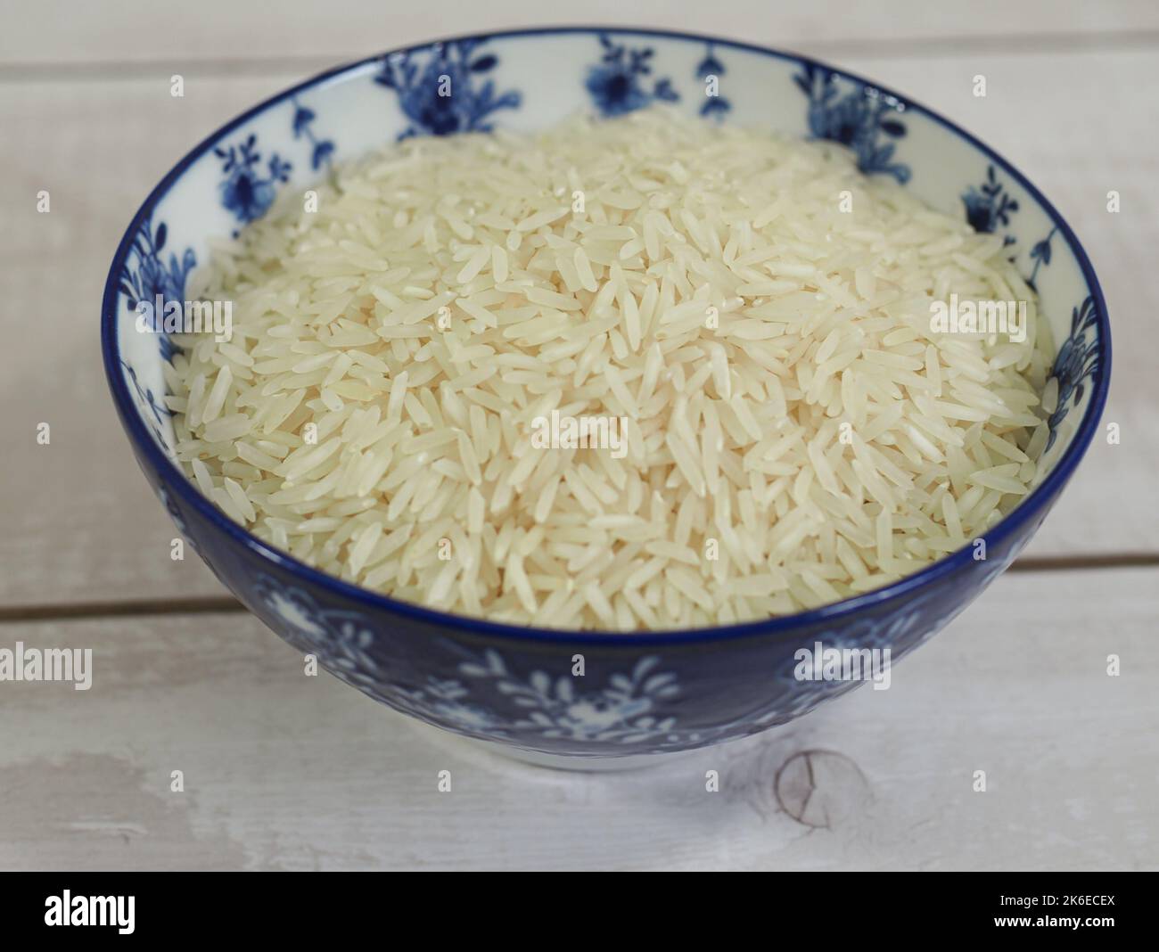 long basmati rice in a blue bowl on white wooden background Stock Photo ...
