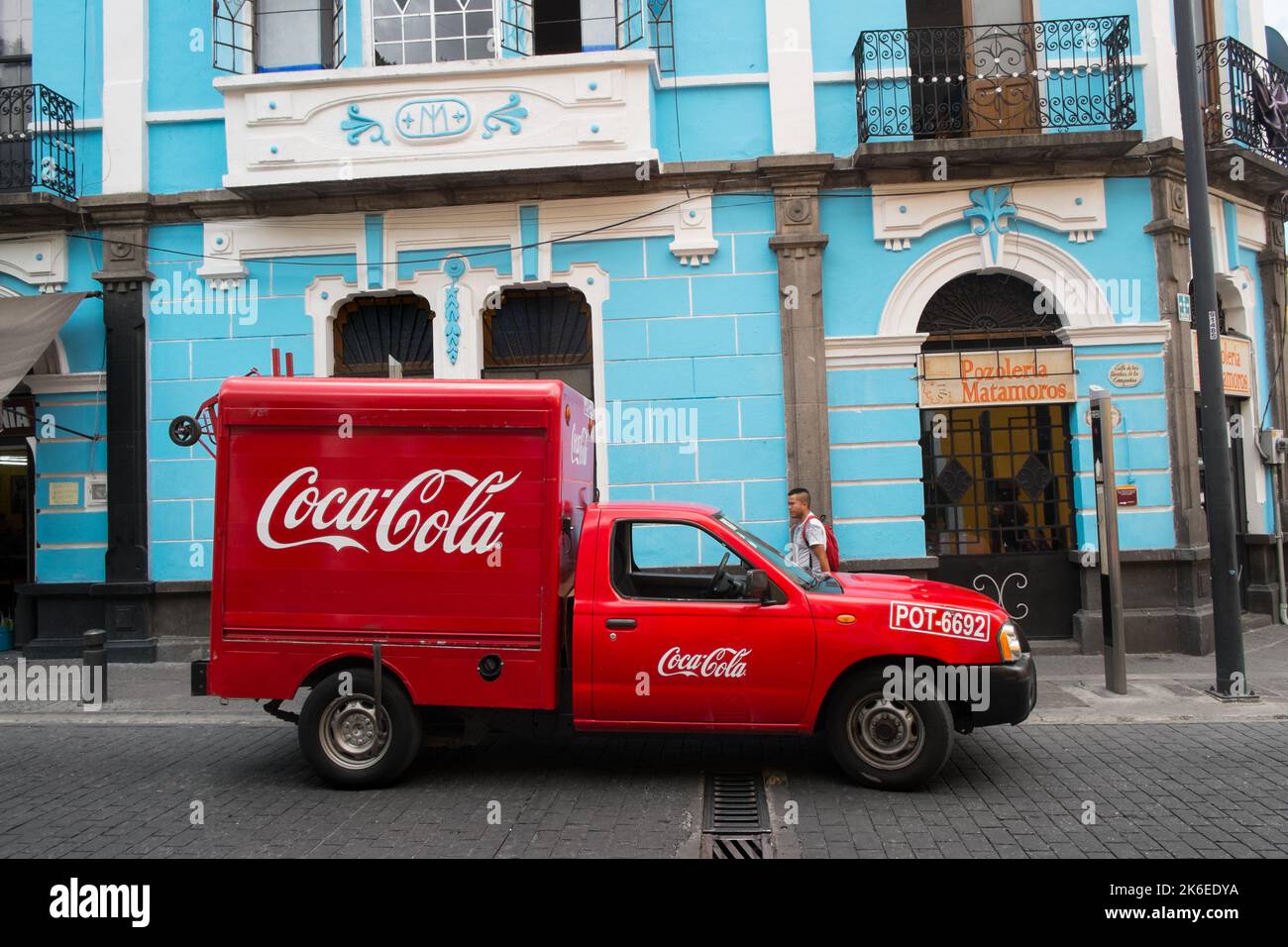 Red Coca-Cola delivery truck, bright blue wall, Puebla, Mexico Stock Photo