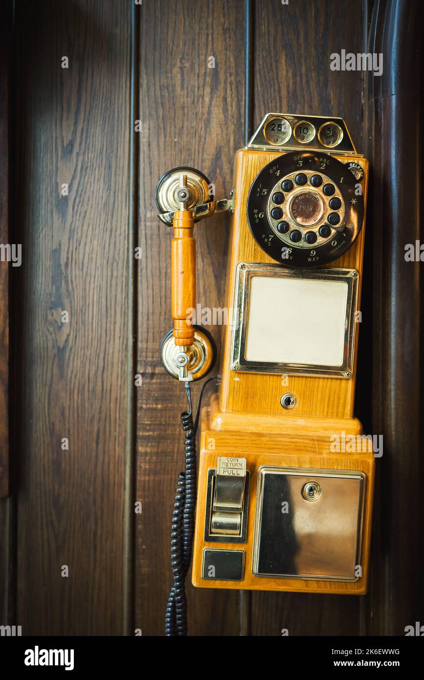 Old vintage rotary telephone hanging on a wooden wall Stock Photo