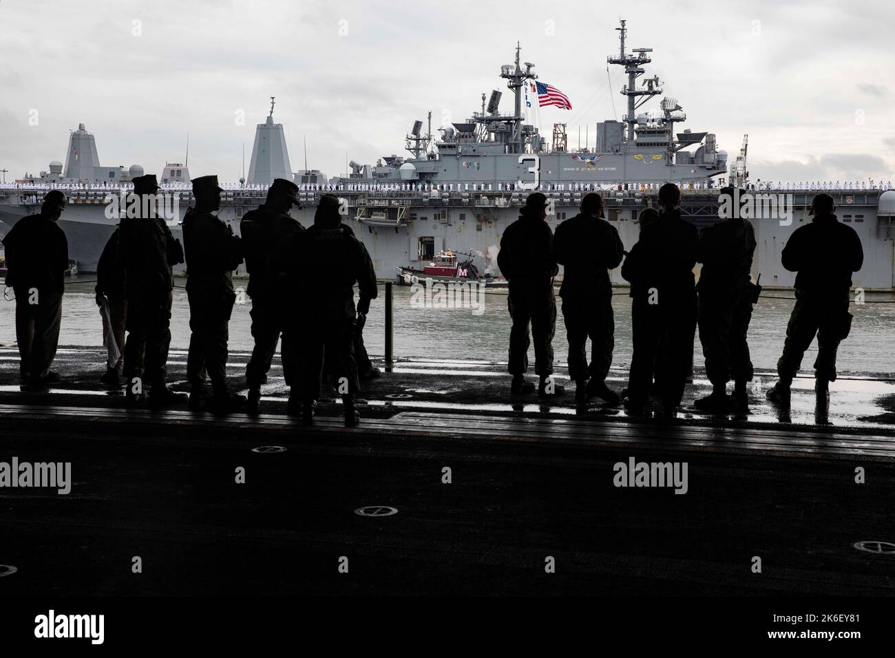 Norfork, United States. 13th Oct, 2022. U.S. Navy sailors aboard the Wasp-class amphibious assault ship USS Wasp watch from the hangar bay as the USS Kearsarge returns to homeport Naval Station Norfolk, October 13, 2022 in Norfork, Virginia. The Kearsarge is returning from a seven-month deployment operating in the High North and Baltic Sea. Credit: MC2 Benjamin F. Davella III/US Navy/Alamy Live News Stock Photo