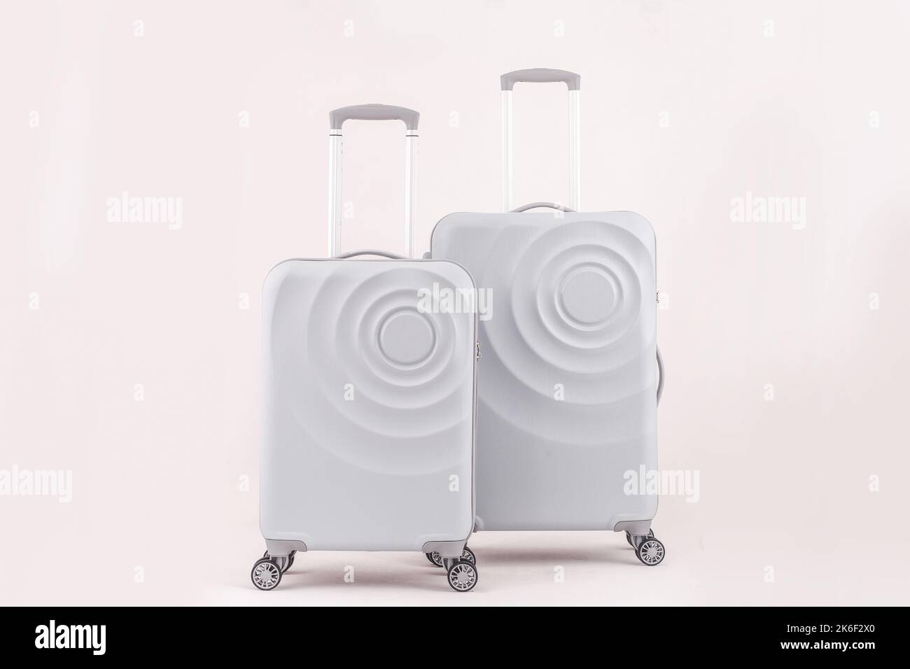2 girly white suitcases isolated on pastel background vacation luggage Stock Photo