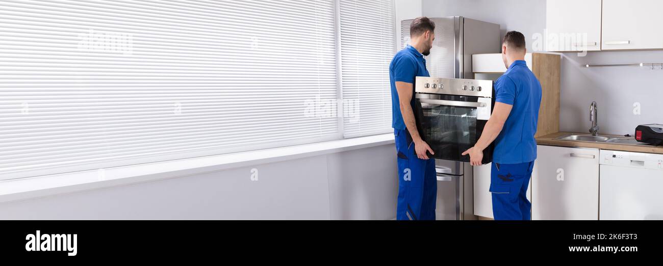 Home Appliance Repair Service. Oven Installation By Repairmen Stock Photo