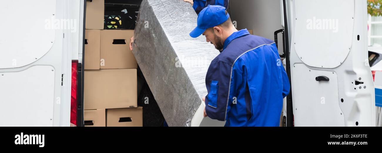 Furniture Mover Unloading Truck. Relocation Delivery Load Stock Photo