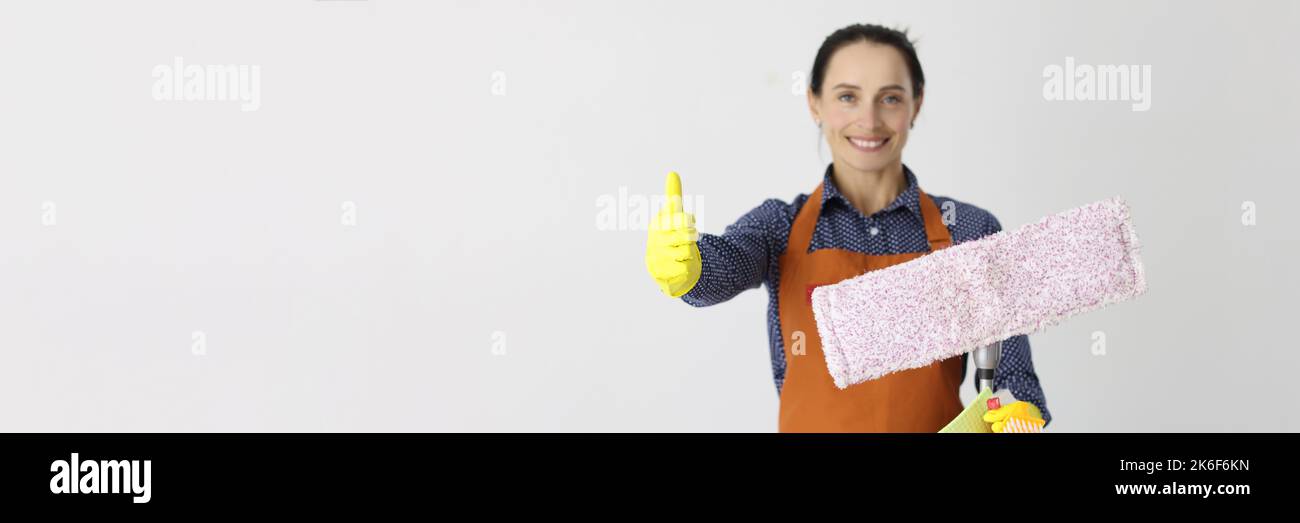 Employee of cleaning company with mop holds thumbs up gesture Stock ...