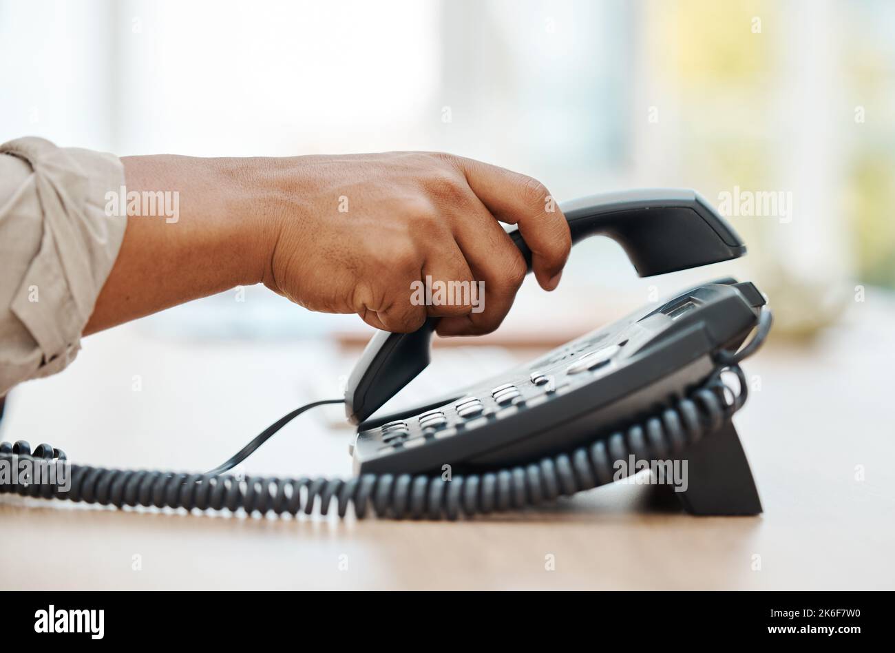 Hand of receptionist on telephone, person contact us in business office