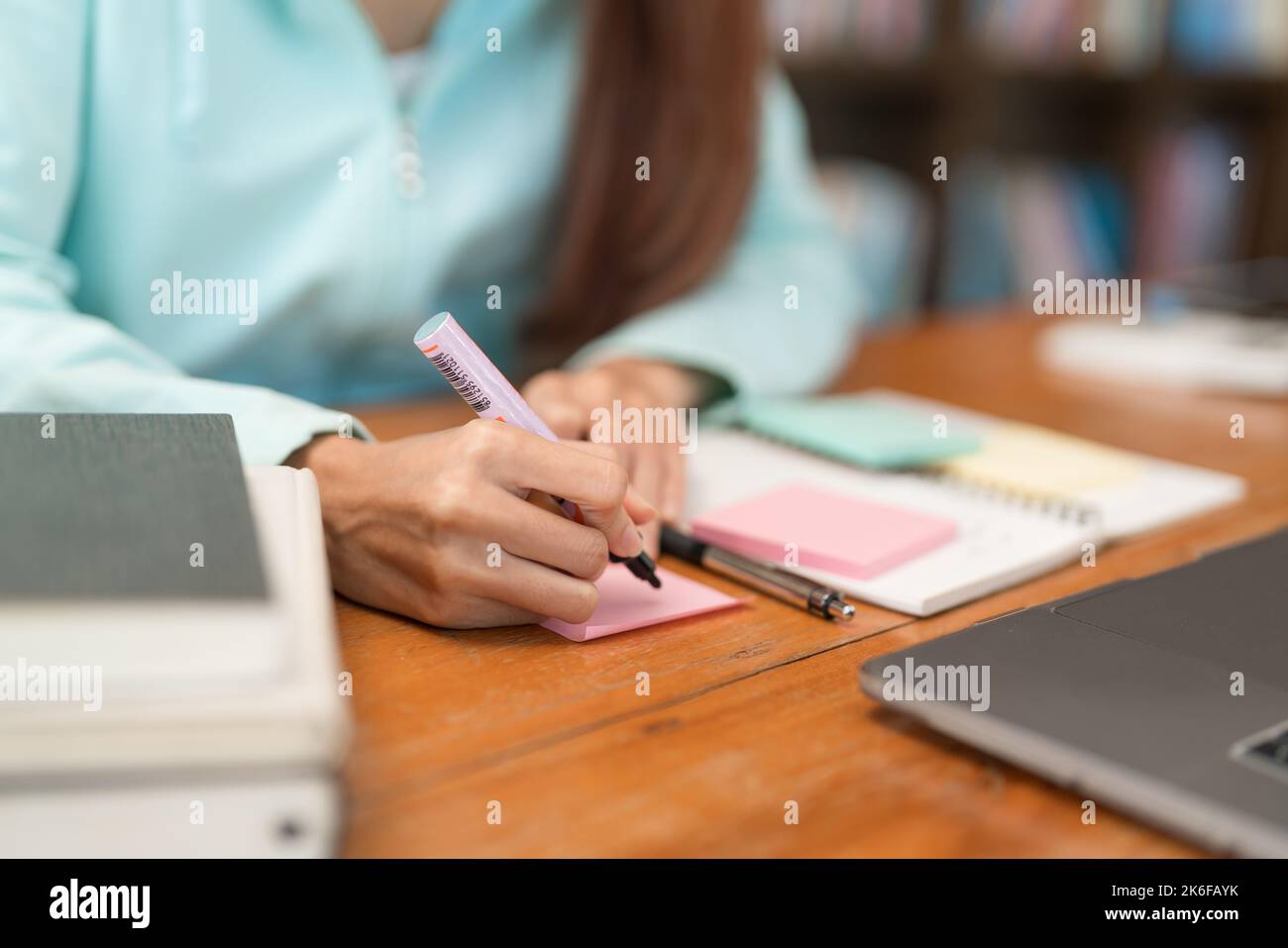 College education concept, Teenage girl is writing  vocabulary on sticky note while study tutorial. Stock Photo