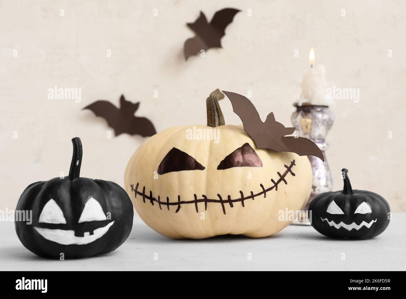 Halloween pumpkins with drawn faces on light table Stock Photo - Alamy