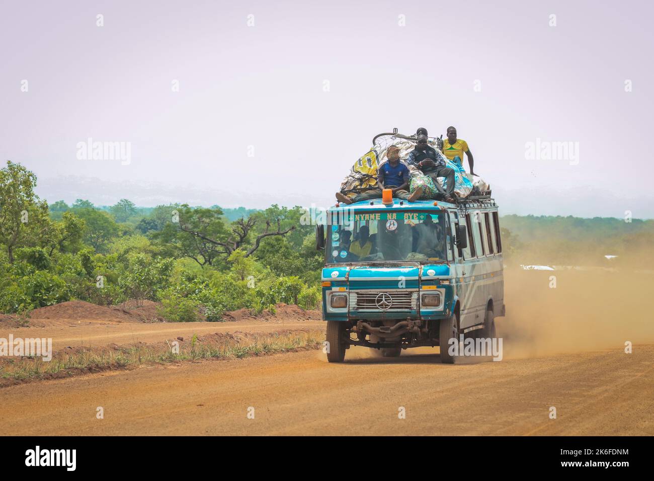 Accra, Ghana - April 01, 2022: Colorful African Public Mini Bus on the Dusty Road in the heart of Ghana Stock Photo