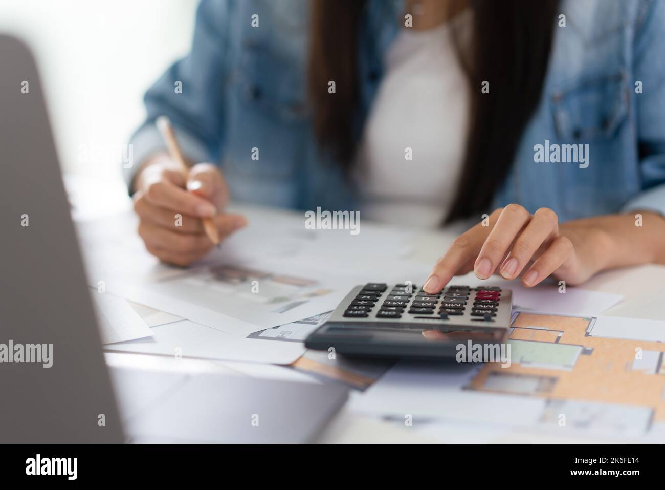 Design building concept, Female architect is using calculator and ...