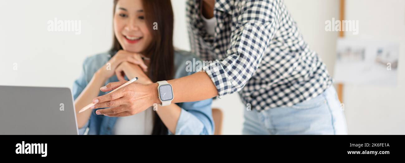 Design building concept, Female architects explaining house plan and project on laptop to colleague. Stock Photo